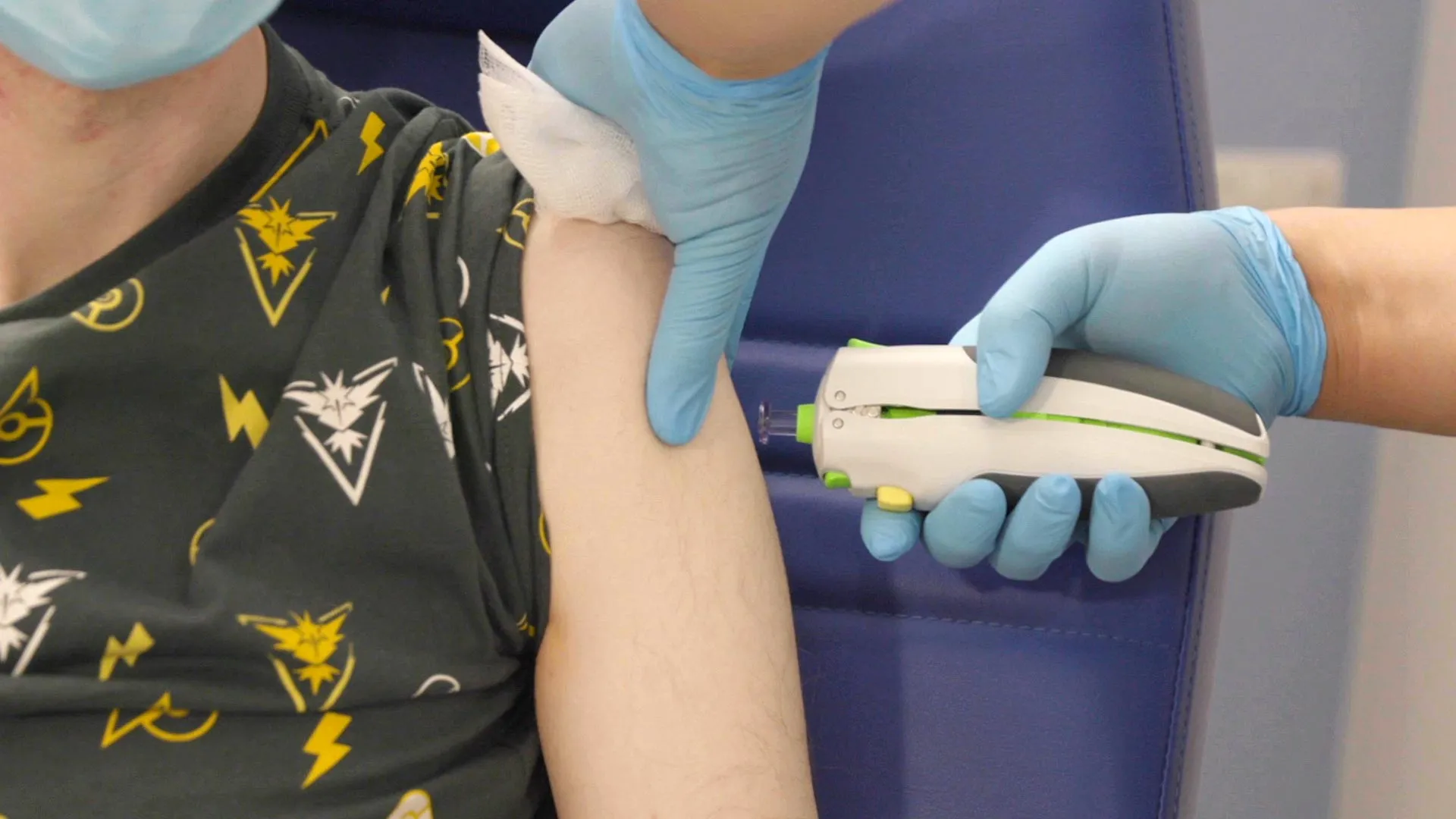 A clinical trial volunteer receiving the AI-designed universal coronavirus vaccine via a needle-free micro fluid jet at a Cambridge trial site