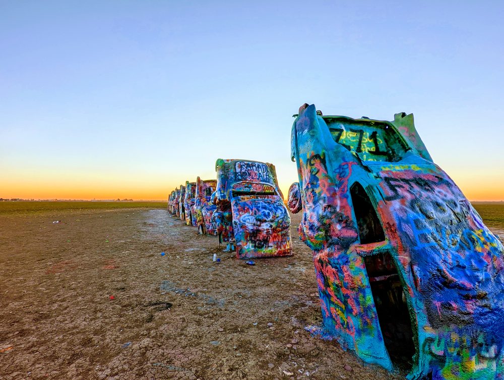 Ten Cadillacs buried nose-down in a field at Cadillac Ranch near Amarillo, Texas, covered in layers of spray paint