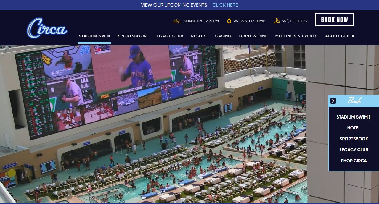 Circa's Stadium Swim pool complex, showing multiple tiered pools packed with guests facing a massive outdoor screen showing live sports