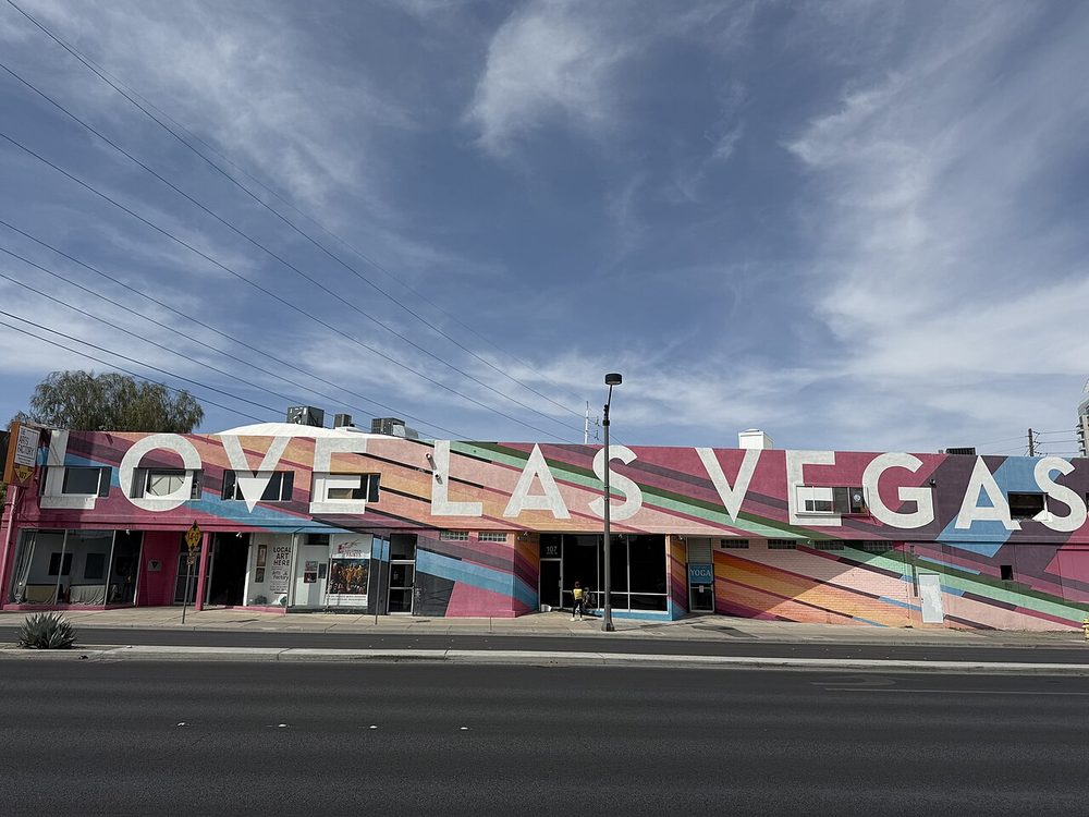 A large rainbow-striped mural reading 'LOVE LAS VEGAS' painted across the entire front facade of The Arts Factory building on Charleston Boulevard