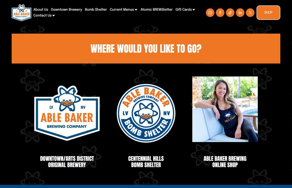 Able Baker Brewing Company's own homepage, reading 'Where Would You Like to Go?' with options for its Downtown/Arts District original brewery, its Centennial Hills Bomb Shelter location, and its online shop