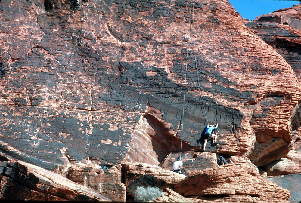 A rock climber ascending a sandstone rock face in Calico Basin at Red Rock Canyon National Conservation Area