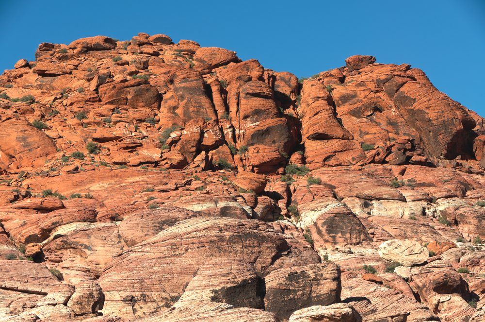A wide view looking up at the multicolored, striped Calico Hills sandstone formations at Red Rock Canyon National Conservation Area outside Las Vegas