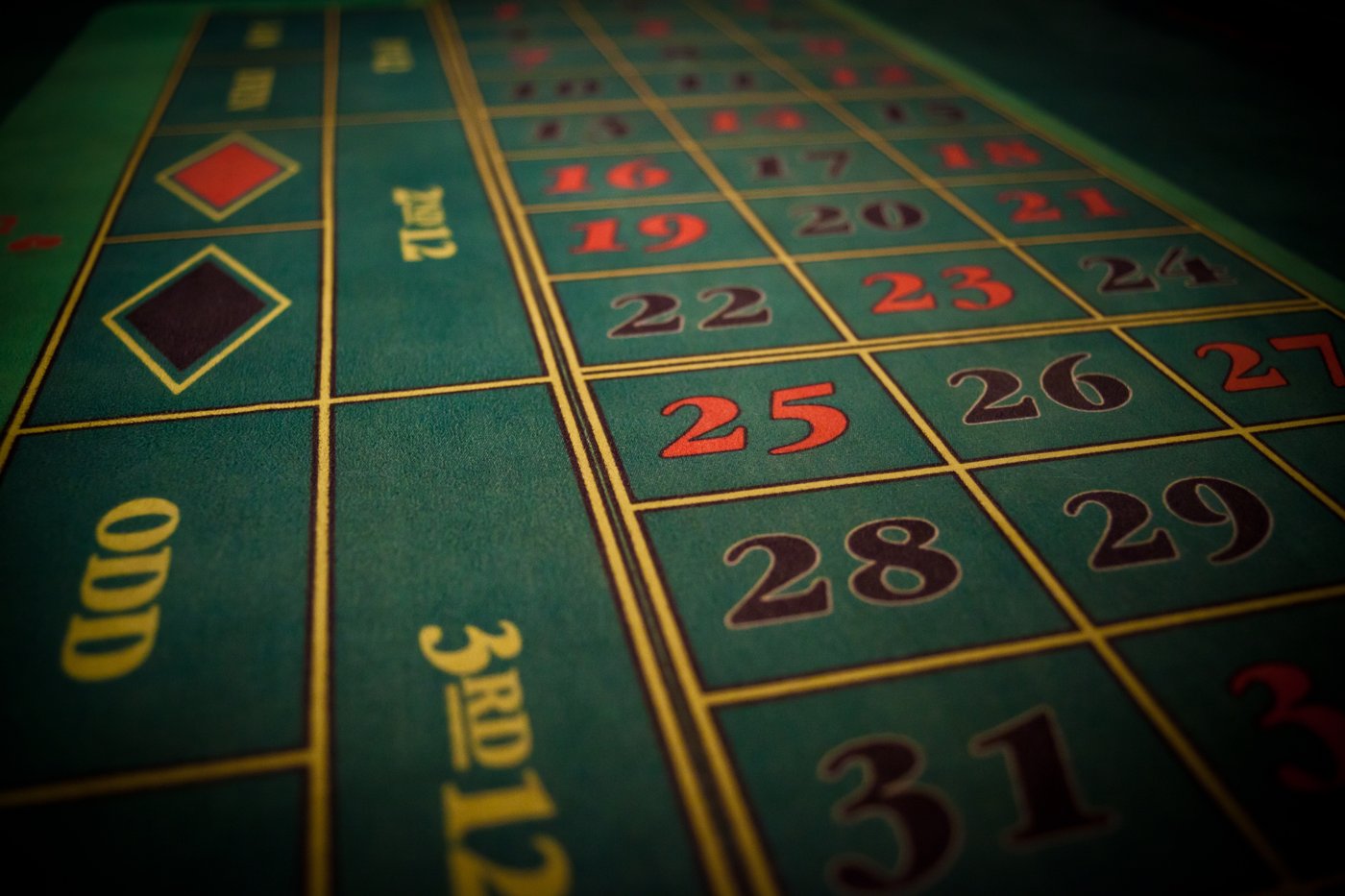 A real photo of a casino roulette table with the green numbered betting layout visible