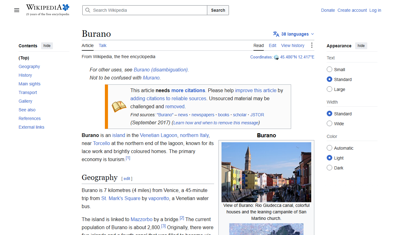 Wikipedia's Burano article showing a photo of the island's brightly colored houses along the Rio Giudecca canal, with the leaning campanile of San Martino church in the background