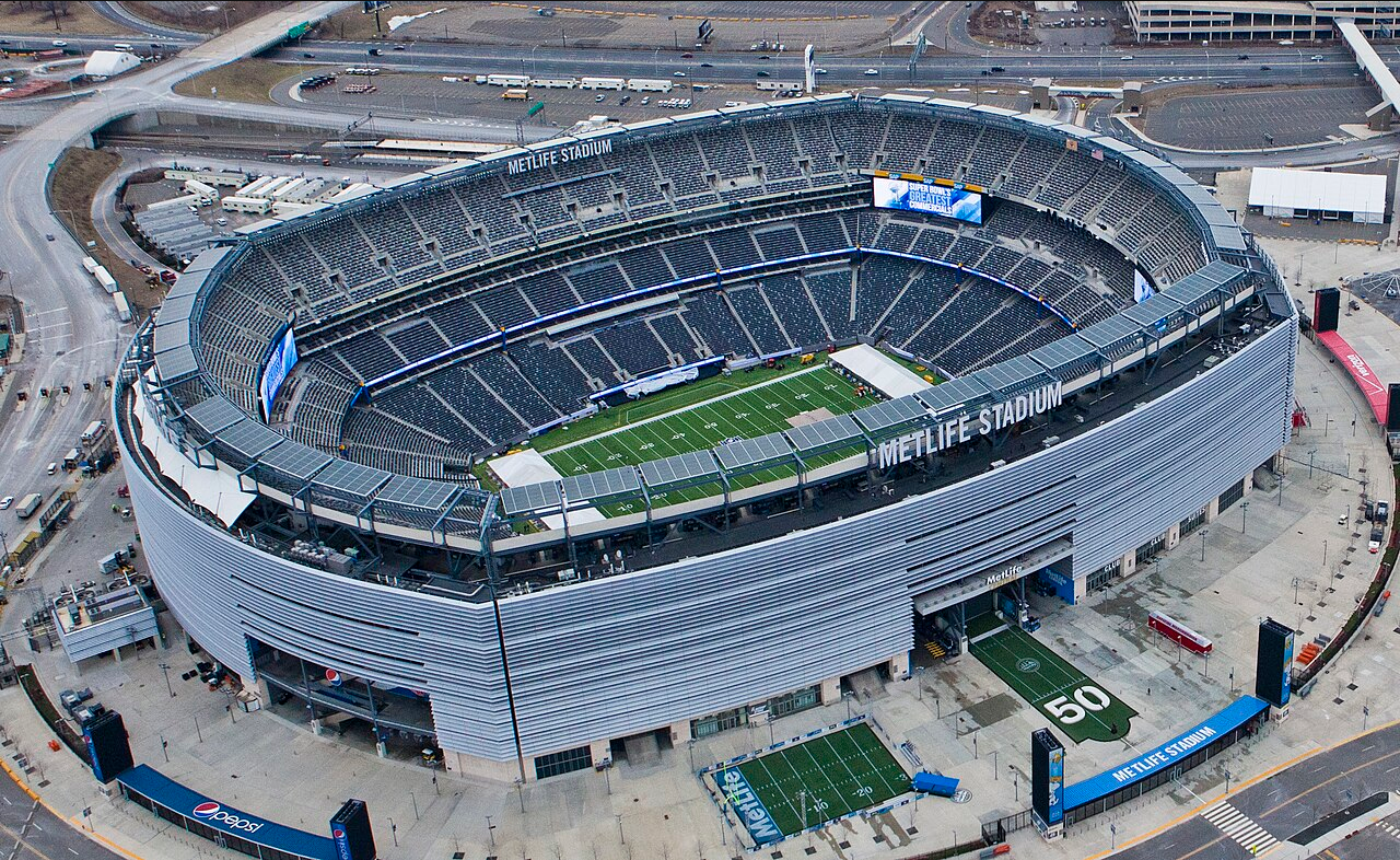 Aerial view of MetLife Stadium in East Rutherford, New Jersey, showing the full bowl, the field, and the surrounding parking and highway complex